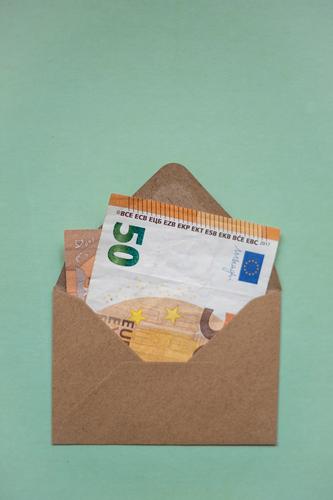 A brown envelope with a bank note inside Bank note Money Envelope 50s 50 euros Euro pretence Gift Donate Donation Invoice Mail Interior shot Save Deserted