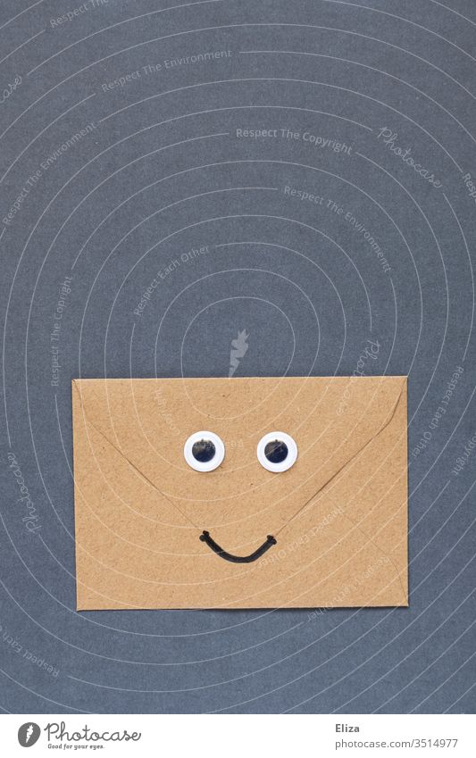 A brown friendly smiling envelope with eyes and mouth Envelope (Mail) Brown Mouth peer smile wobbly eyes kind good news Joy Eyes Face Letter (Mail) Communicate