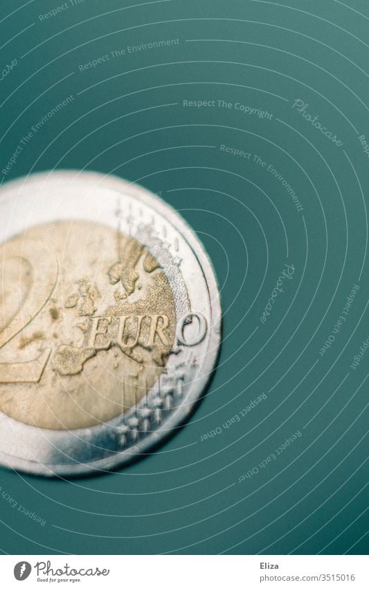 Close-up of a two euro coin against a turquoise background; money, finances Money Macro (Extreme close-up) Euro Bright Financial Statements Save