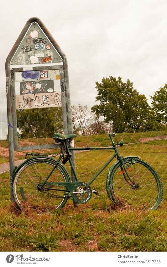 green bicycle connected to a sign Bicycle Associated Road sign Meadow turned off Lonely Exterior shot Transport Colour photo Deserted Signage Safety