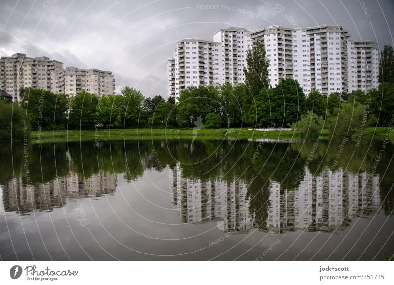 Strange quarter Sky Clouds Pond Tower block Facade Modern Gloomy Environment Deprived area Residential area Green space Urban development Silhouette Reflection