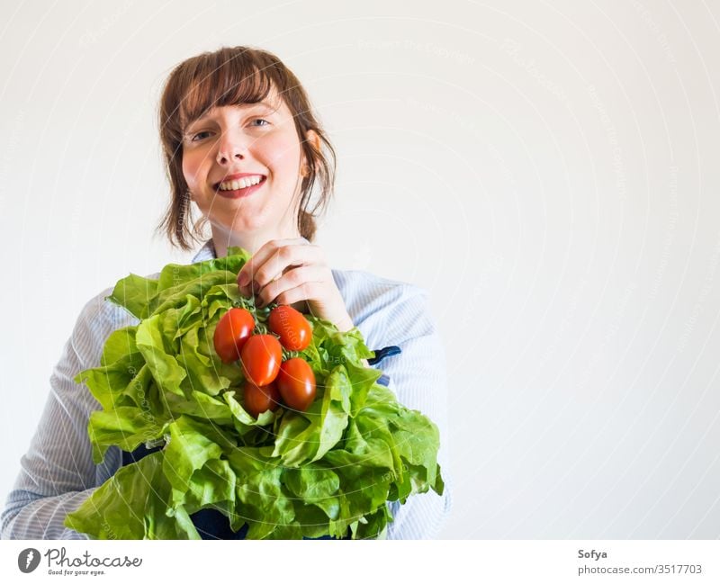 Woman in blue apron with fresh produce in hand food delivery grocery store shop owner local groceries hands green staples safe girl foodstuff face holding