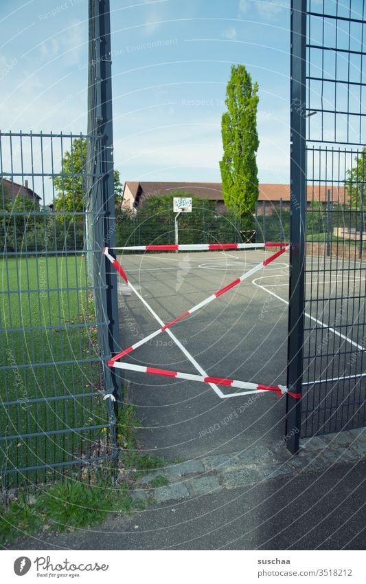 still closed? cordoned off sports field Basketball arena Basketball basket Closed Empty Grating barrier tape Lawn lines opening Passage obstructed stay home