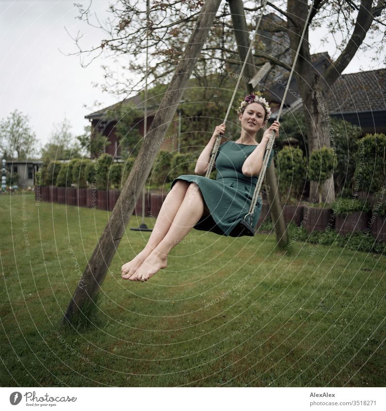 Analogue portrait of a young woman on a swing in the garden with a wreath of flowers in her hair Garden Woman already Athletic Slim Flower wreath Swing green