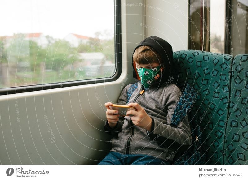 Boy with face mask sitting in public transport Boy (child) Child Mask Protection Mouth and nose mask mns Face mask Community mask Commuter trains Public transit