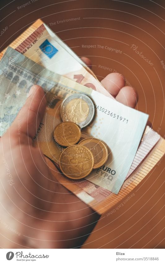 A person holding euro banknotes and coins Money Euro Notes by hand stop Give finance gratuity Paying Coin Financial Industry Loose change pay cash Shopping