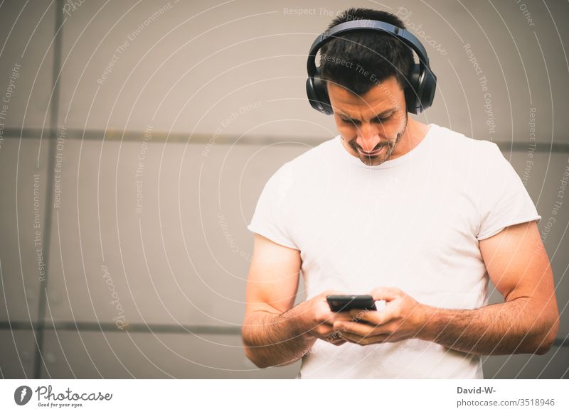Man listens to music on his mobile phone with Bluetooth headphones Connection Joinery technique ally Electronics Technology Advancement Future Modern Music
