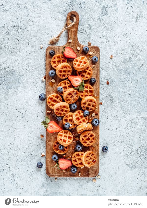 Delicious belgian waffles with berries, copy space blueberry belgium round small delicious cutting board dessert strawberry breakfast food fresh sauce tasty