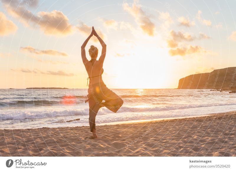 Woman practicing yoga on sea beach at sunset. peace woman girl body relax health exercise ocean sunrise spirituality zen lifestyle young sky nature outdoor