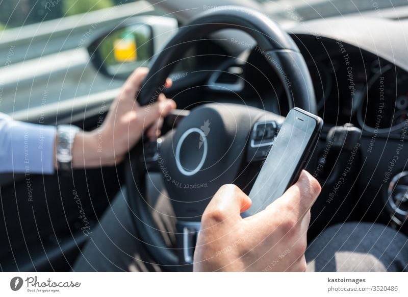 Businessman texting on his mobile phone while driving. car driver technology business person automobile using businessman dangerous traffic transportation cell