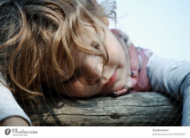 Little girl leans with closed eyes over a wooden railing and dreams Child Infancy rest portrait Sweet Blonde Calm Trust Face hair Joist Handrail Closed