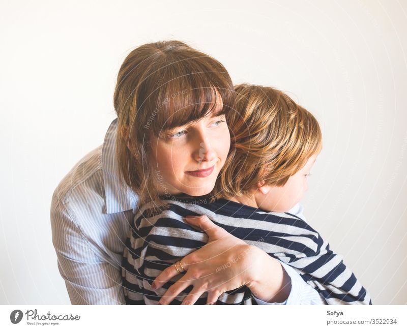 Young mother and child hugging. Mothers day mom parent mothers day woman lifestyle kid love son together family emotion feelings face eyes caucasian happy