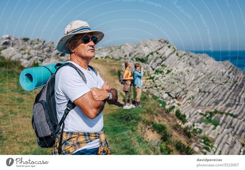 Senior man trekking looking at the landscape hikers senior retired nature hat sunglasses countryside summer mountain recreation people hiking field spring