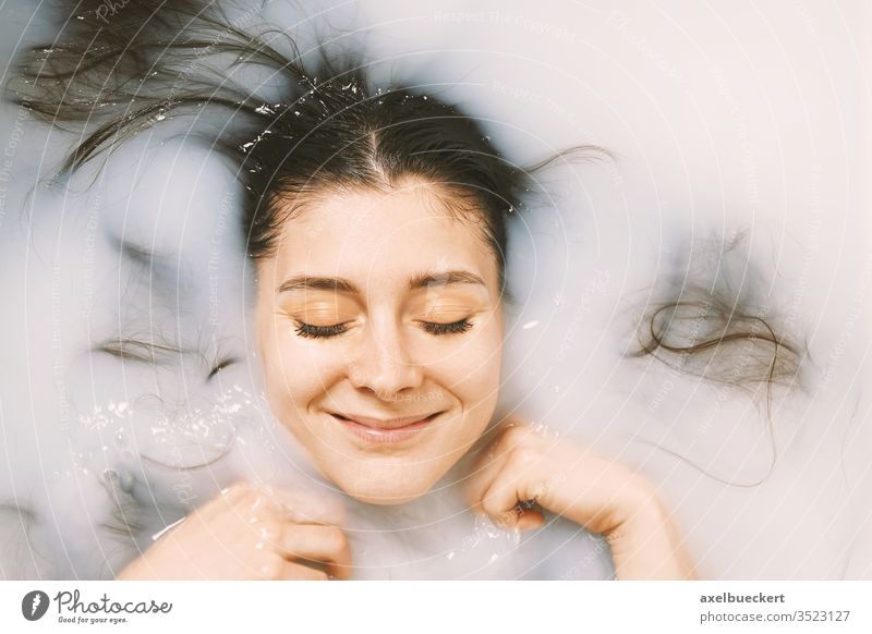 happy young woman taking a bath in milk girl self-care bathing wellbeing pamper beauty portrait skin body personal people health water relax wellness white