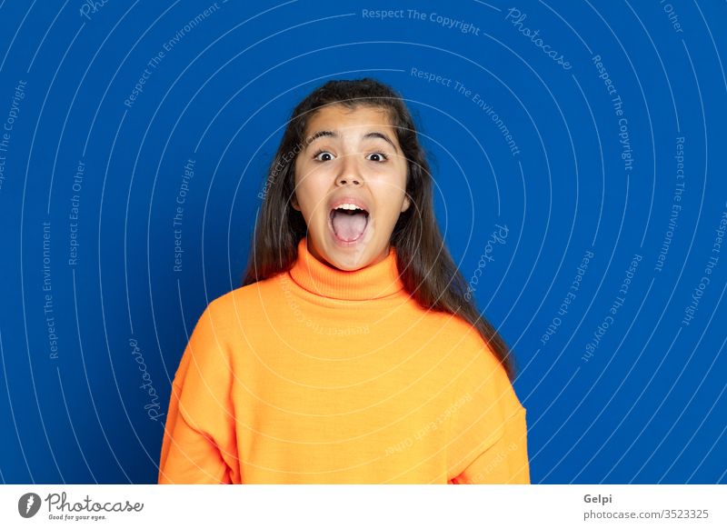 Preteen girl with yellow jersey preteen blue surprised exciting crazy scary emotion amazing shout female people person pretty attractive background teenager