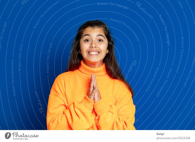 Preteen girl with yellow jersey preteen blue hand luck wish desire want pray religion meditation believe female people person pretty attractive background