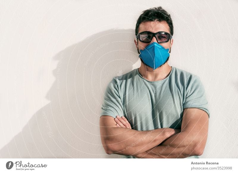 Man with facial mask and sunglasses looking at camera man corona virus allergy cool eyeglasses covid 19 contagion disease confinement pandemic protection
