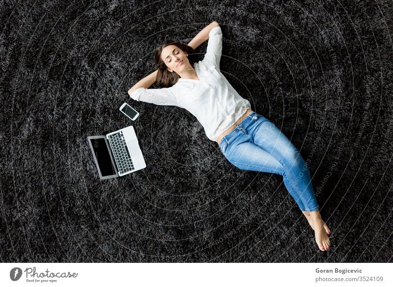 Young woman laying on the carpet back laptop floor girl phone charming leisure view red european adult people caucasian female computer modern lifestyle young