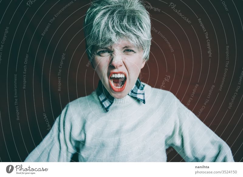 Portrait of a really angry androgynous woman rage rude sign expressive furious emotional mood portrait portraiture short hair red hair finger loud scream