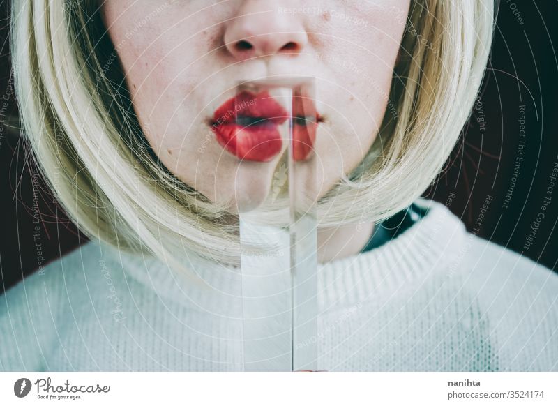 Close up of a young woman's face covering by a prism art close up glass crystal distortion reflection lips blond blonde mouth cold clean silence secret timidity