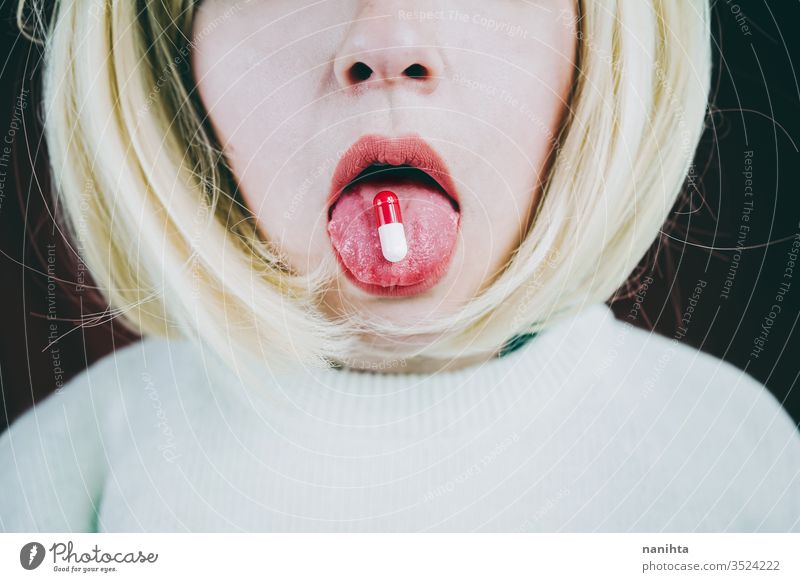Conceptual image about drug addict with a pill in a young woman tongue addiction mouth medicine painkiller pain killler anestesic medical treatment lick sexy