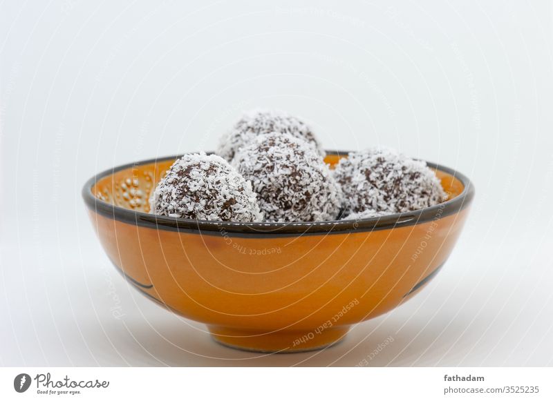 Coconut balls in an orange ball background bowl brown coco coco ball coconut coconut balls cookie delicious dessert food homemade isolated old bowl