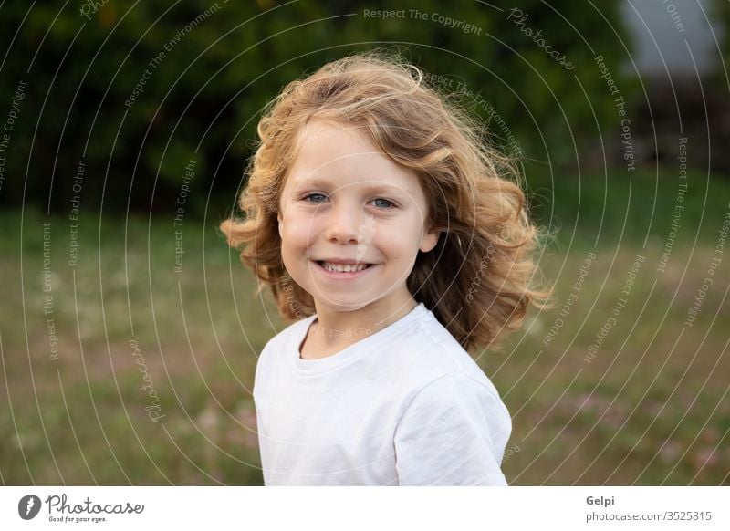 Funny blond kid with long hair child outside one childhood people caucasian joy boy little nature wavy play summer young outdoor fun happy playful lifestyle
