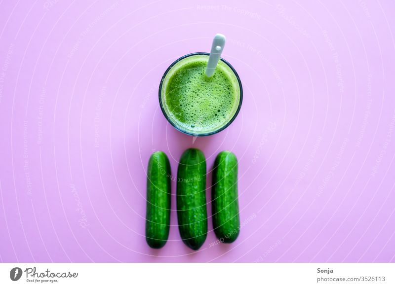 Fresh cucumber juice in a glass and whole cucumbers on a pink background, top view Cucumber Small Juice glass smoothie green detox Healthy Eating Beverage Diet
