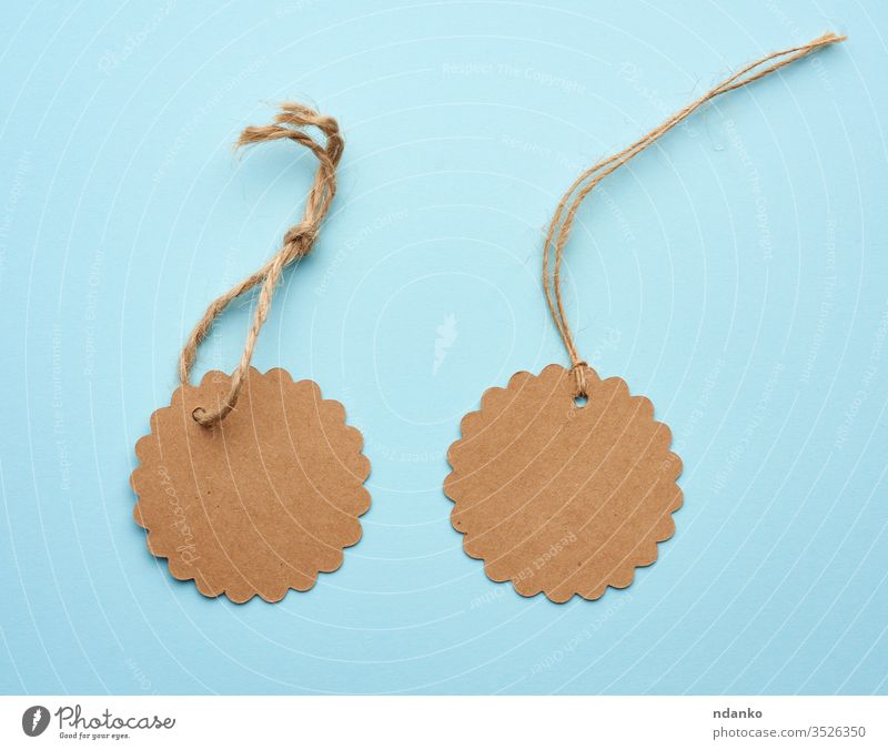Round empty brown paper tag tied with string price pricing recycled blue address background blank business buy card cardboard cord coupon craft design discount