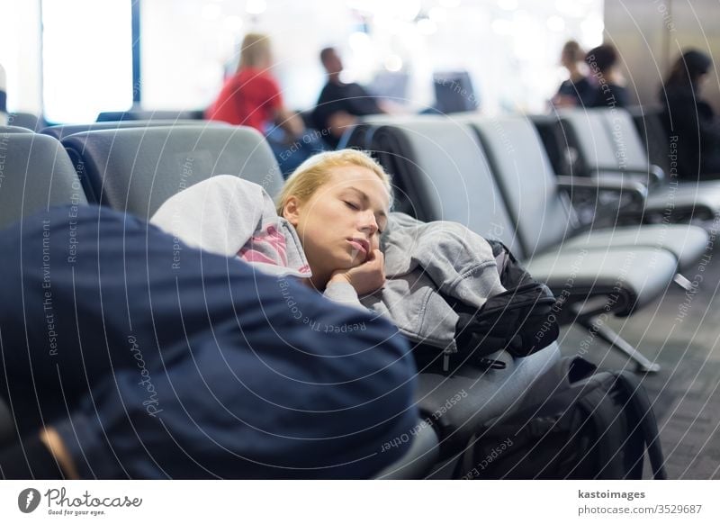 Tired female traveler sleeping on airport. woman rest nap wait station delay patience luggage train baggage flight tourist gates immigration railway platform