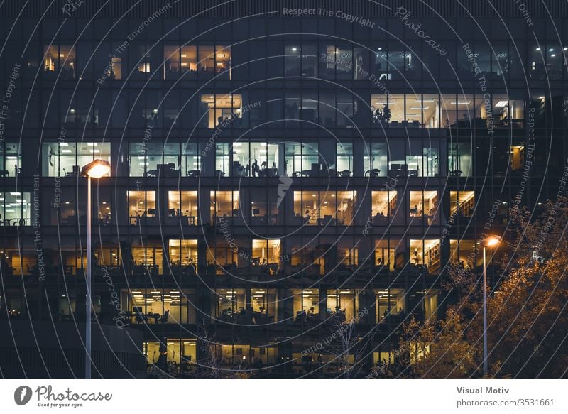 Illuminated windows of an office building at night lights illuminated rows frontal wide streetlamps color exterior outdoor outdoors city urban architecture