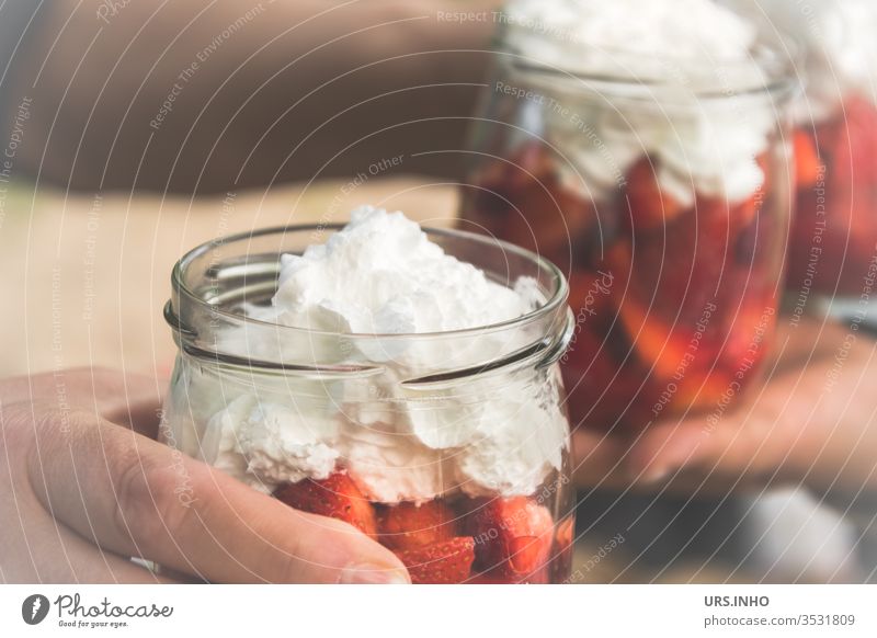 preserving jars with sliced strawberries and cream topping Strawberry Preserving jar Cream icing on the cake Dessert Eating nib feed sb./sth. Nutrition by hand