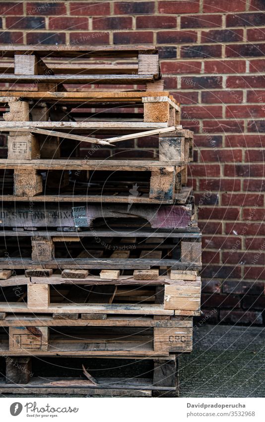 Shabby wooden pallets near brick wall box dirty stack red colorful building grunge pile exterior worn out vivid daylight facade shabby timber construction cargo