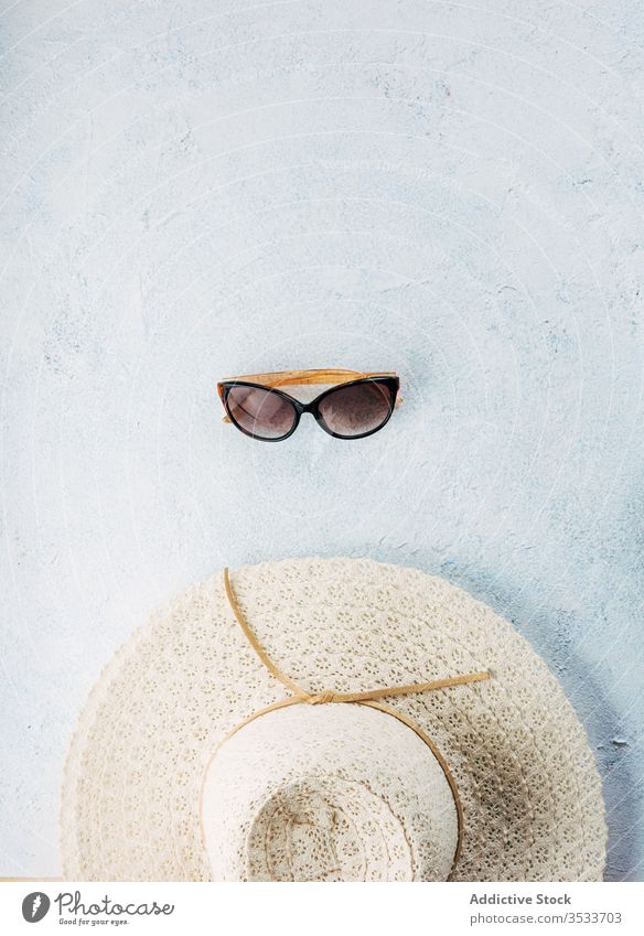 Sunglasses and hat on stucco surface sunglasses summer vacation style accessory beach composition trendy fashion plaster travel tourism trip journey holiday