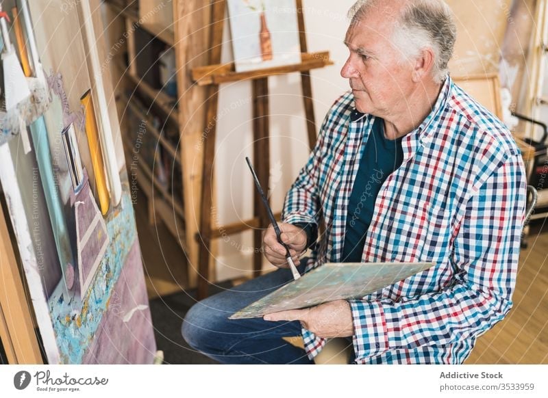 Aged man painting picture with brush artist aged paintbrush home inspiration draw concentrate palette oil easel paper studio hobby workshop gallery equipment