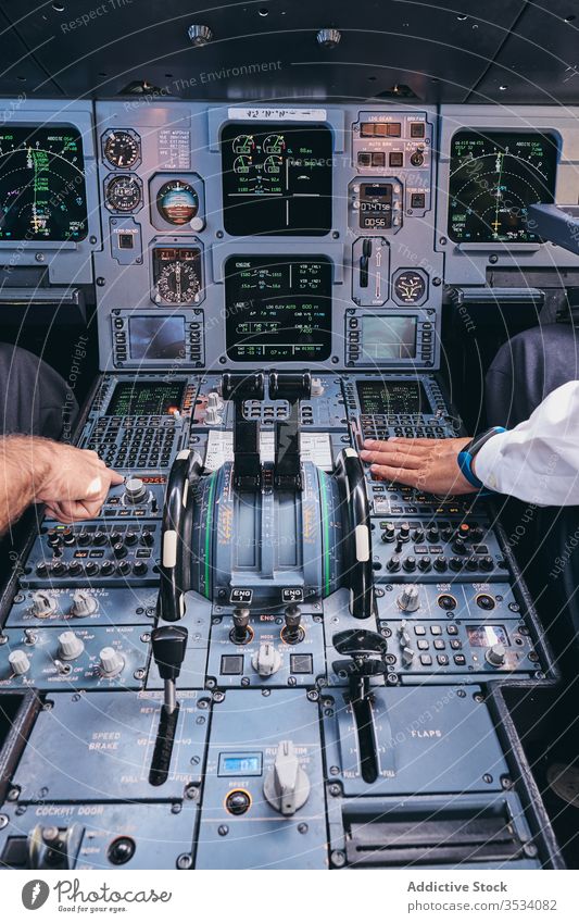 Pilots working in cockpit during flight pilot operate men airplane control dashboard equipment aviator male captain check modern aircraft transport instrument