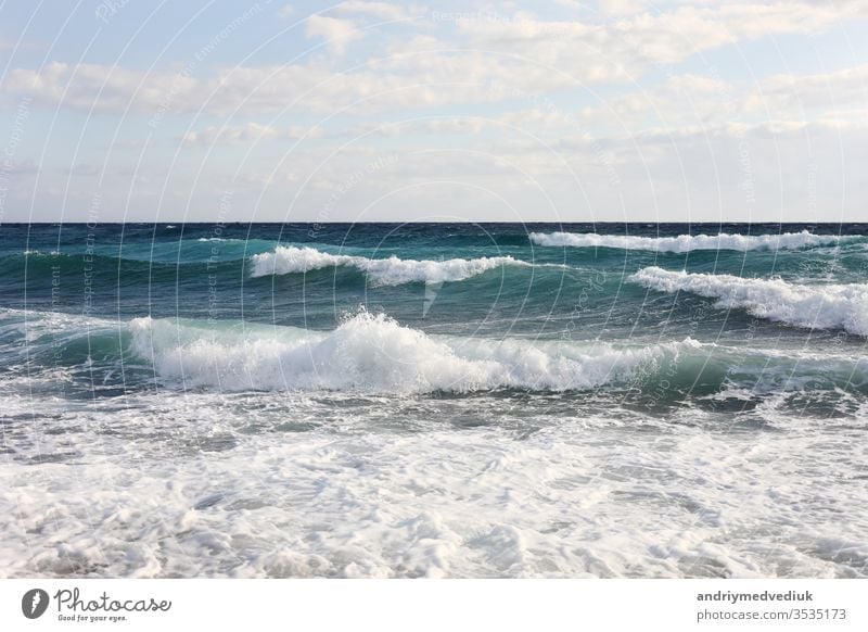 sea waves on the surface of sea water during strong winds and bad weather, sunny day, sky with clouds. ocean travel splash blue nature white big background