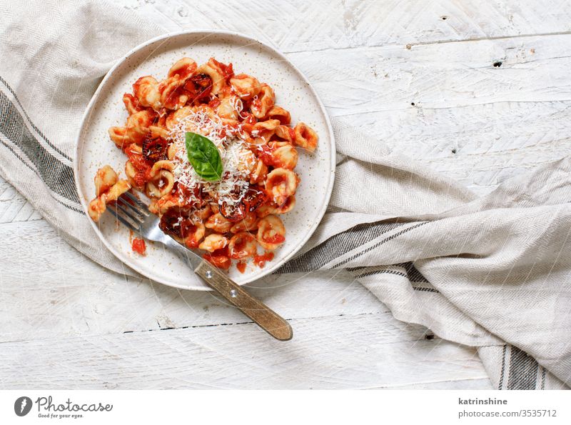 South italian  pasta orecchiette with tomato sauce and cacioricotta cheese apulia tomatoes sugo top view white copy space negative space wooden cooked cuisine