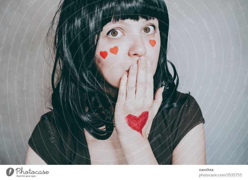 Beautiful portrait of a young woman with red hearts in her face love beauty pretty artistic valentines valentine's day in love romantic elegant natural brunette