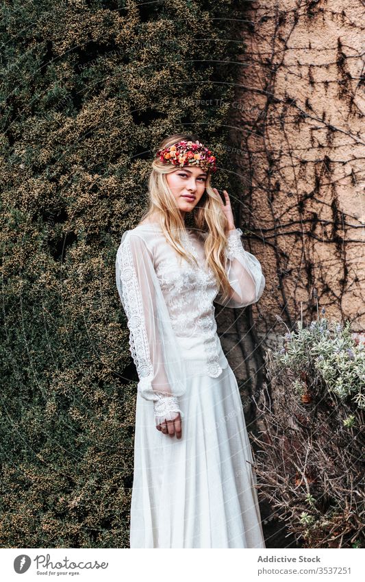 Young bride standing near old estate woman house yard bush vine flora elegant wedding female young dress wreath aged potted flower style celebrate serene decor