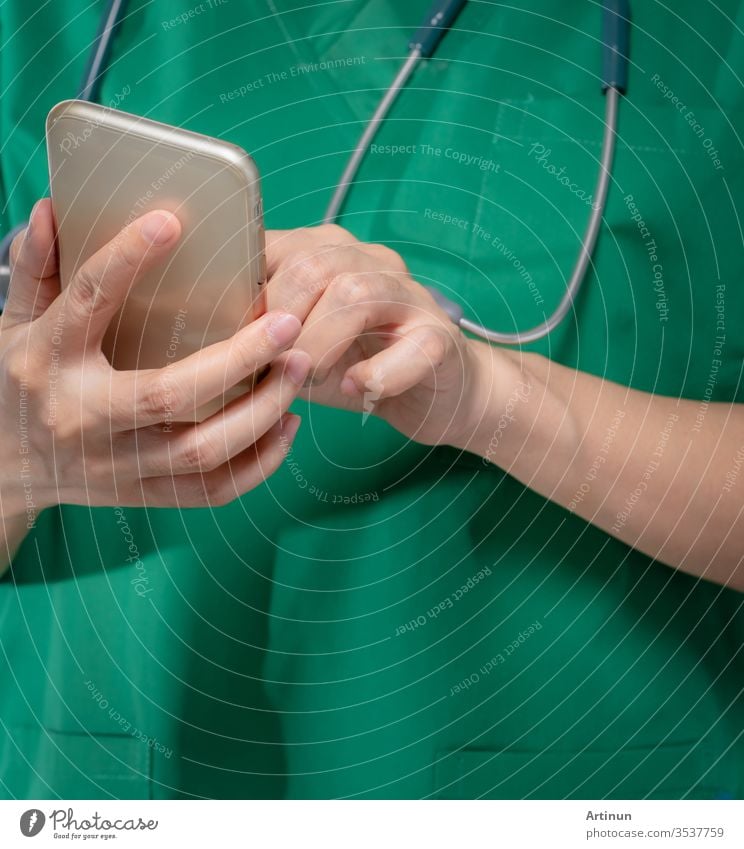 Doctor with stethoscope use mobile phone to communicate with healthcare providers or patient. Surgeon hand holding smartphone. Medical health application on mobile phone. Telemedicine concept.