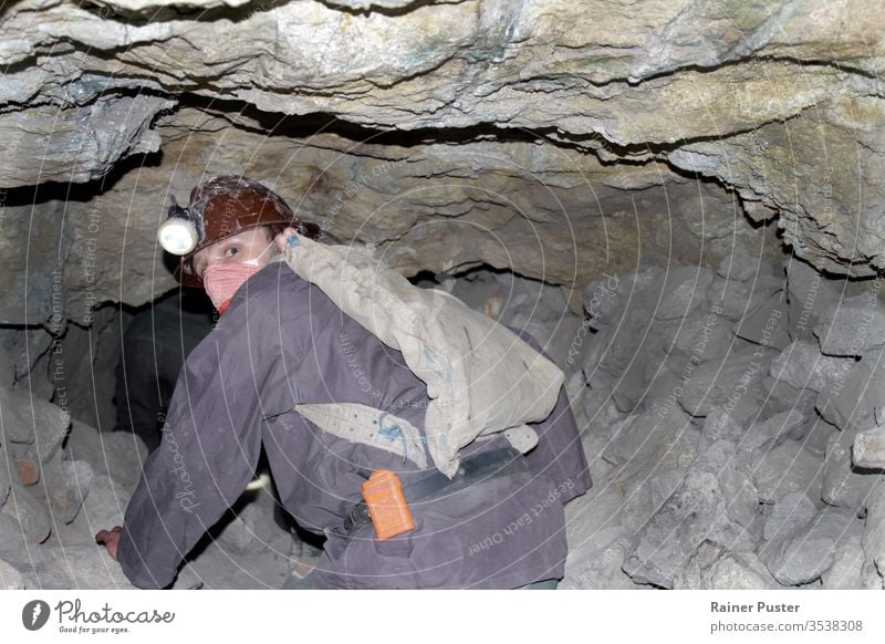 A miner crawling through a dangerously unstable shaft of a mine in Cerro Rico. bolivia bolivian cerro rico coal dangerous occupation dangerous work dirty