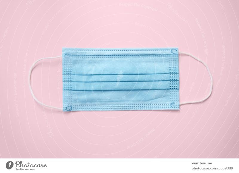 COVID-19 disposable surgical face mask on pink background. Protection against coronavirus. Healthcare and medical concept covid19 surgical mask pattern blue