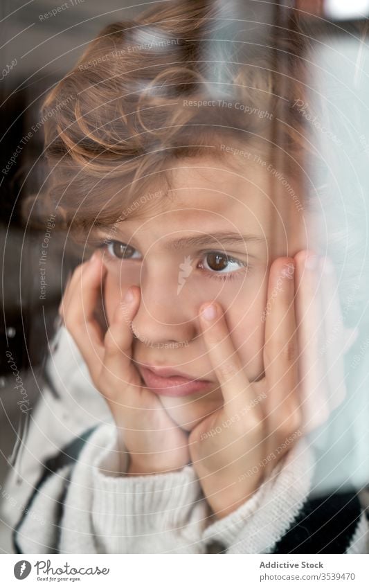 Bored boy looking out wet window bored rain hand on cheek rest home cozy weather child kid sad childhood tranquil lifestyle lonely adorable calm unhappy