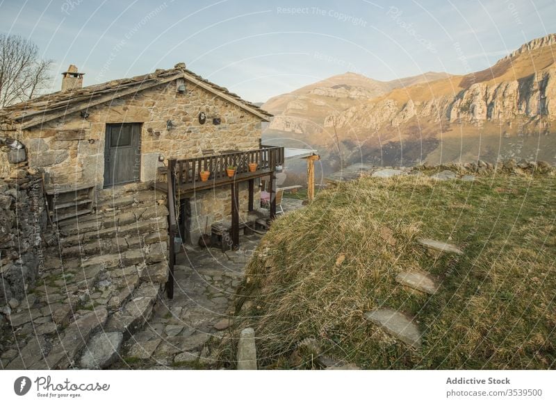Old stone house with small wooden terrace in mountainous area in Spain countryside terrain architecture building aged remote peaceful landscape village spain