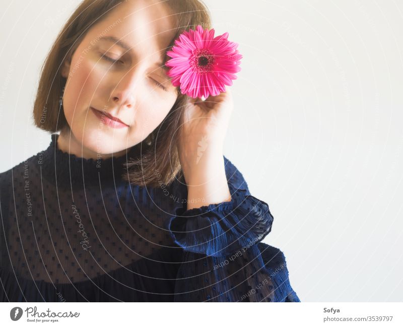 Beautiful female portrait with pink gerbera flower woman beauty mothers day fashion one unique skin eyes care face young hand holding spring springtime romantic