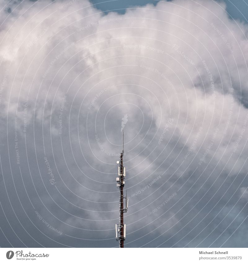 Transmitter mast in front of mighty clouds Broacaster Broadcasting tower Sky Blue Antenna Clouds Technology Telecommunications Deserted Colour photo Communicate