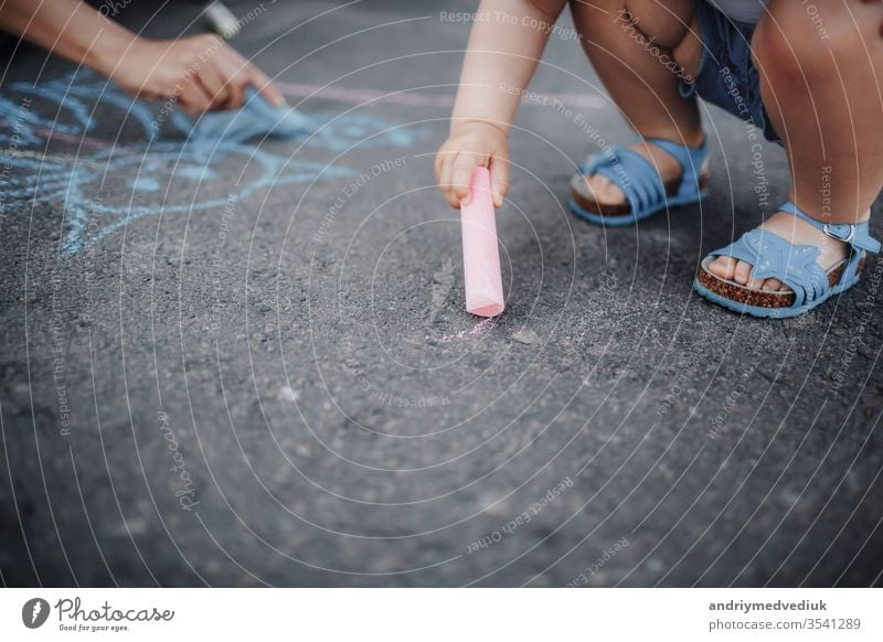 Close up of little girl drawing with chalks on the sidewalk color hand pavement art summer background colorful fun outdoor child park leisure small kid play