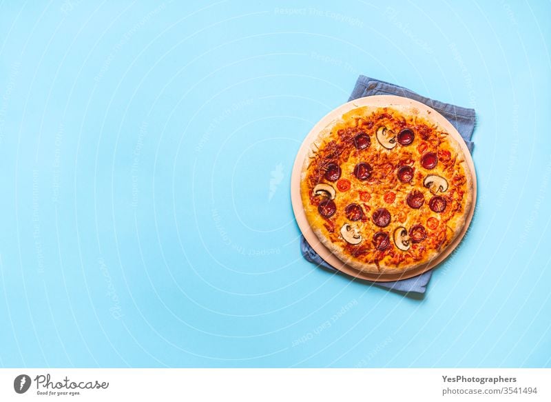 Pizza pepperoni hot from the oven. Homemade pizza Italian above view artisan authentic baked blue background cheese convenience food cooked copy space cuisine