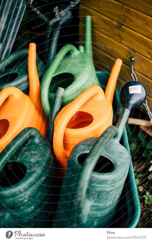 Different coloured watering cans variegated green Orange Gardening Watering can Gardener Devices Cast Empty Day